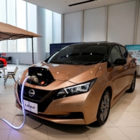 A Nissan Leaf EV car and portable battery are displayed at the Nissan Gallery in Yokohama last November. | REUTERS