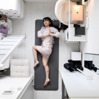 Asumi Fujiwara practices yoga in her apartment in Tokyo on Aug. 31. Tiny new apartments in Japan are pushing the boundaries of normal living.  | NORIKO HAYASHI / THE NEW YORK TIMES
