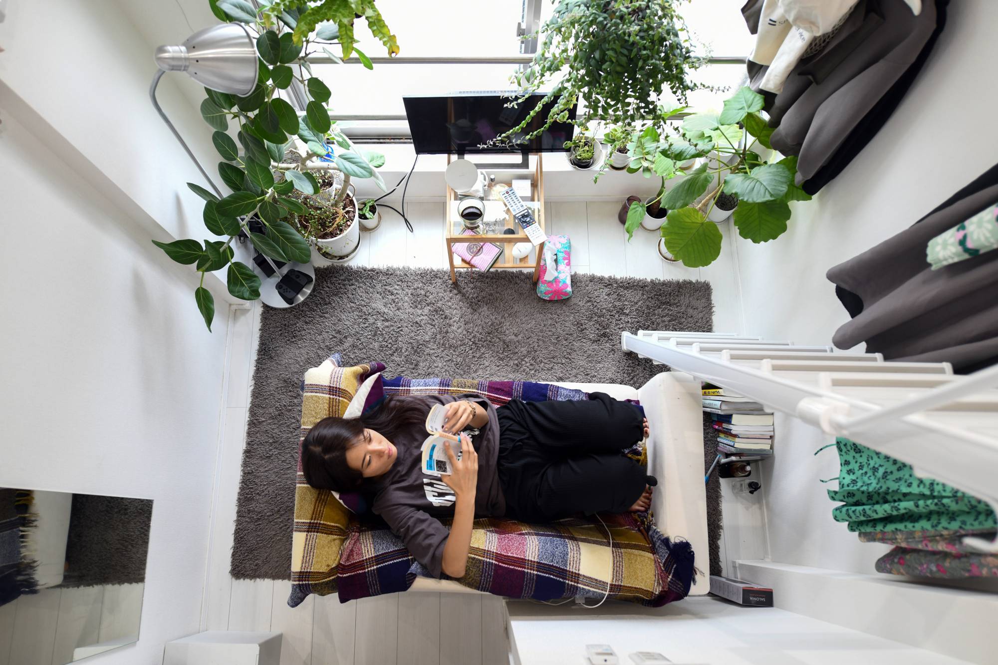 Kana Komatsubara, 26, in her apartment in Tokyo on Sept. 24. Tiny new apartments in Japan are pushing the boundaries of normal living. | Noriko Hayashi / The New York Times