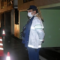 A police officer stands guard near the home of Isamu Ono in Sapporo on Monday. | KYODO