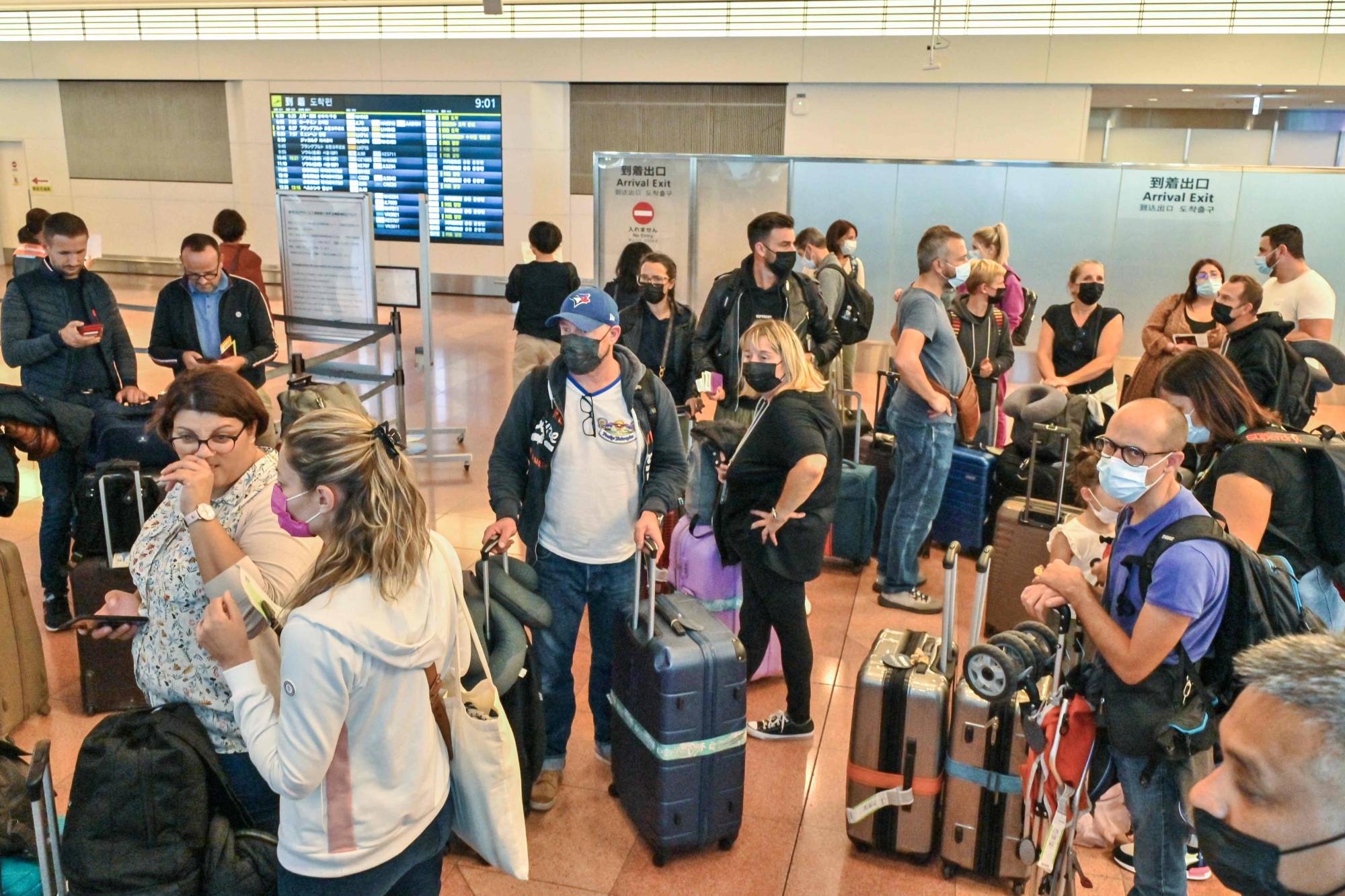 A group of tourists arrive at the international terminal of Tokyo's Haneda Airport on Tuesday, when Japan reopened to foreign independent travelers after two-and-a-half years of COVID-19 restrictions. | AFP-JIJI