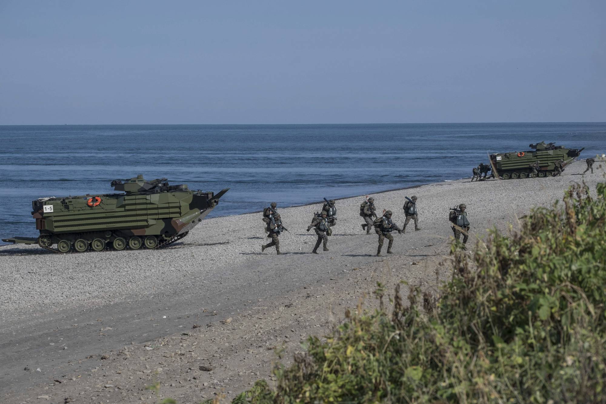 Taiwanese military personnel participate in an amphibious landing as part of military exercises in Pingtung, Taiwan, on July 28. | LAM YIK FEI / THE NEW YORK TIMES