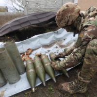 A member of the Ukrainian National Guard prepares shells for a D-30 howitzer in the Kharkiv region of Ukraine on Oct. 5. | REUTERS