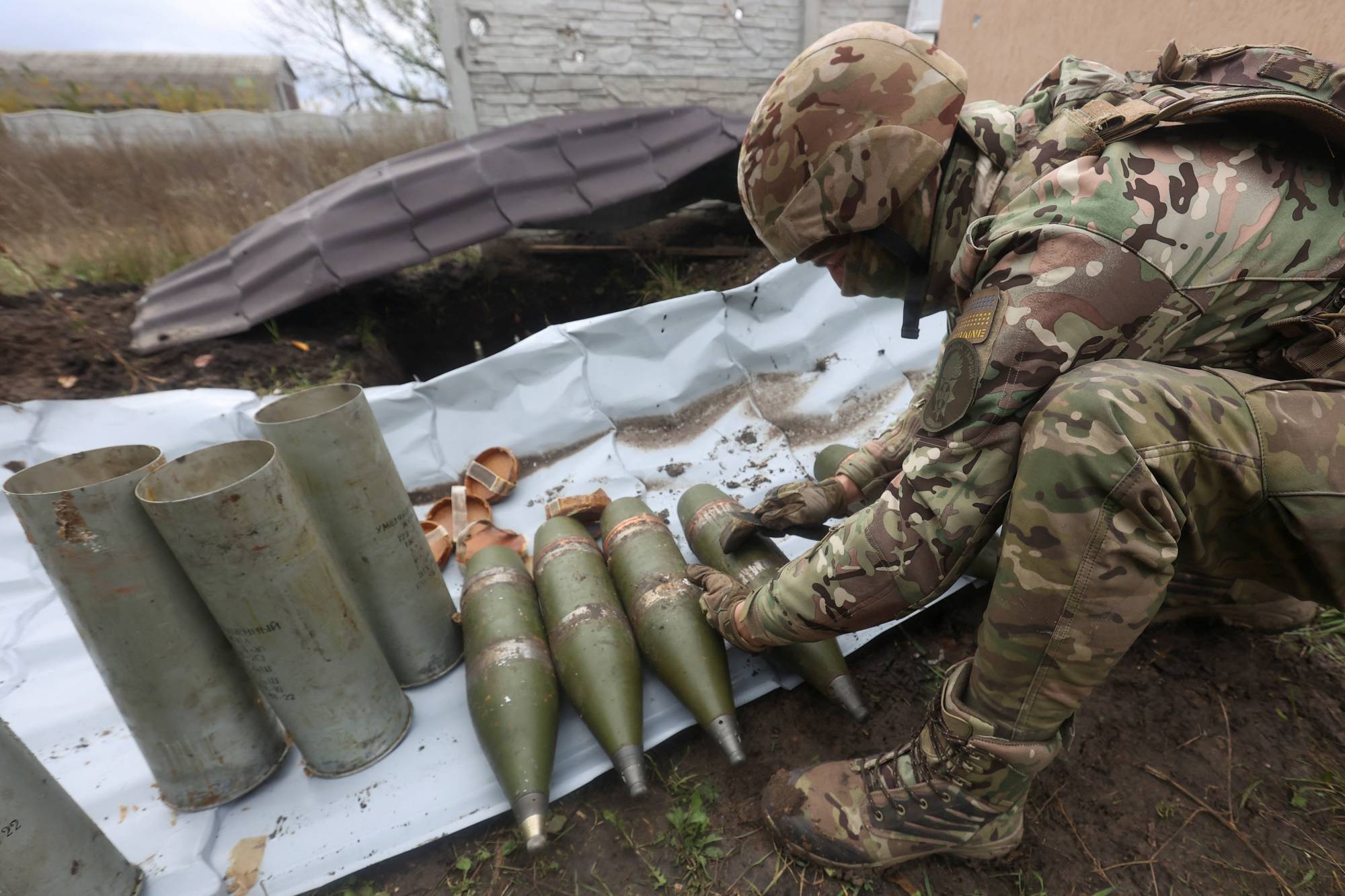 A member of the Ukrainian National Guard prepares shells for a D-30 howitzer in the Kharkiv region of Ukraine on Oct. 5. | REUTERS