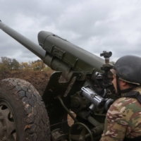 A member of the Ukrainian National Guard prepares a D-30 howitzer for fire toward Russian troops in the Kharkiv region on Oct. 5. | REUTERS