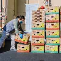 Vue Vang collects donated food from a Trader Joe\'s in Fresno, California, where, under a new law, grocery stores are required to donate \"the maximum amount of edible food that would otherwise be disposed.\" | ANDRI TAMBUNAN / THE NEW YORK TIMES
