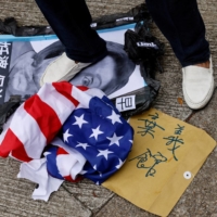 A pro-China supporter steps on a defaced photo of U.S. House of Representatives Speaker Nancy Pelosi during a protest against her visit to Taiwan, outside the Consulate General of the United States in Hong Kong on Aug. 3. | REUTERS