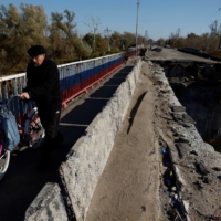 A man pushes his bicycle in the recently retaken town of Kupiansk, Ukraine, on Tuesday | REUTERS