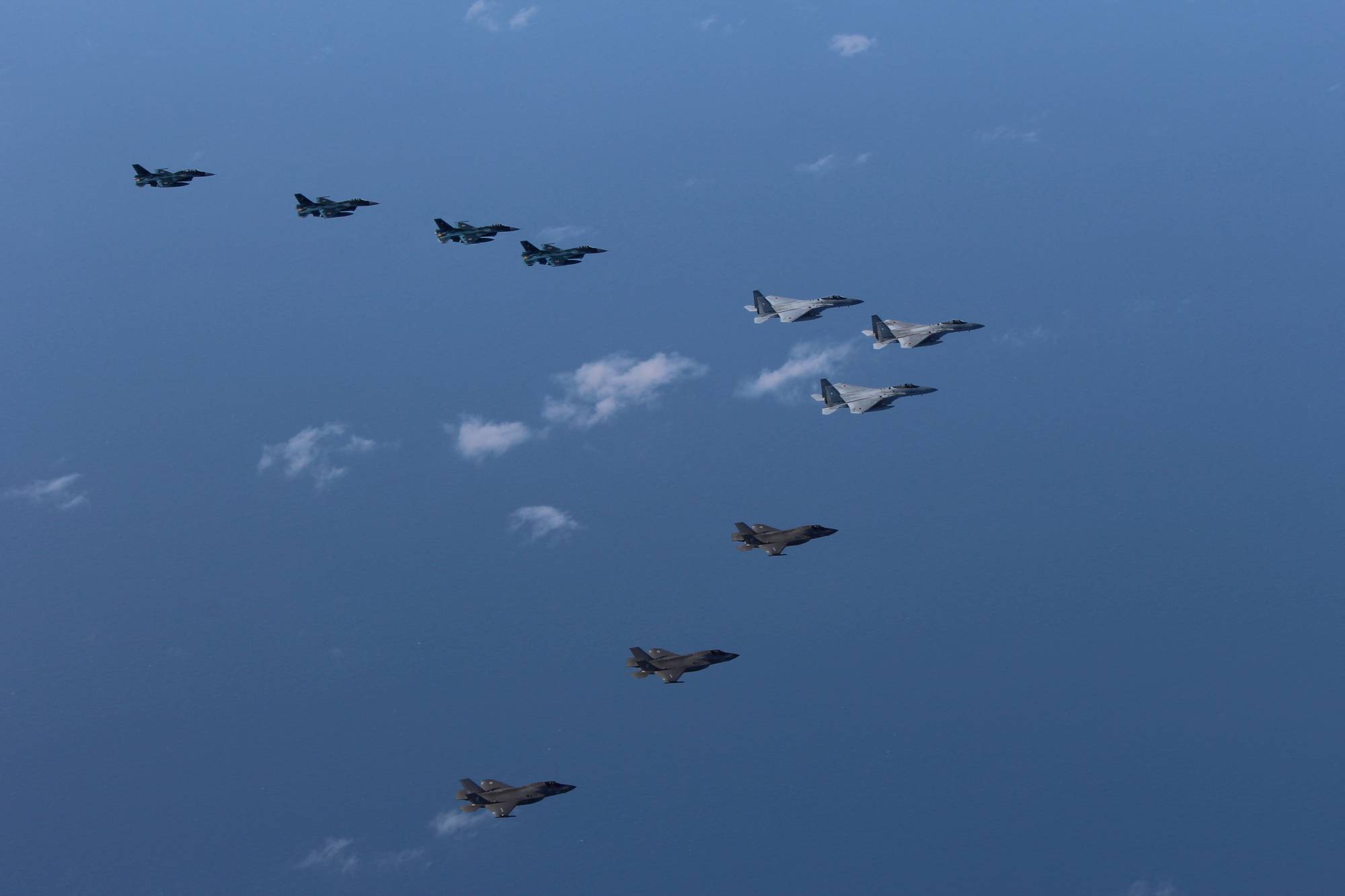 Air Self-Defense Force F-15 and F-2 fighters hold a joint military drill with U.S. Marine Corps F-35B fighters off Kyushu on Oct. 4. | DEFENSE MINISTRY JOINT STAFF OFFICE / VIA REUTERS