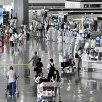 The departure lobby for international flights at Narita Airport in August. The government Wednesday said it no longer requests that residents in Japan refrain from nonessential trips to any country due to infectious diseases. | KYODO
