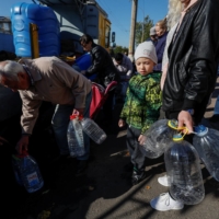 Local people fill up bottles with fresh drinking water in Mykolaiv on Sunday, as the main supply pipeline for drinking water for the city was damaged in Kherson region at the at the beginning of Russia\'s attack on Ukraine. | REUTERS