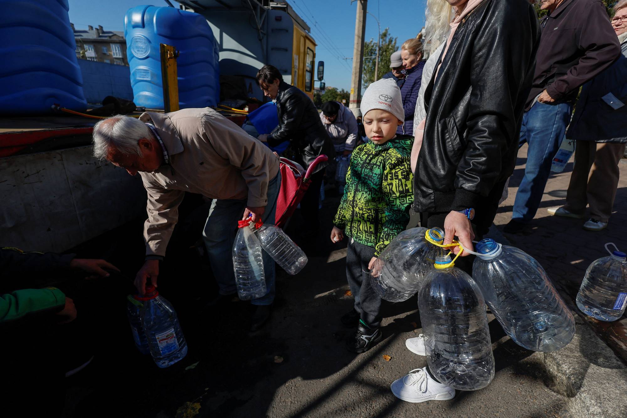 Local people fill up bottles with fresh drinking water in Mykolaiv on Sunday, as the main supply pipeline for drinking water for the city was damaged in Kherson region at the at the beginning of Russia's attack on Ukraine. | Reuters
