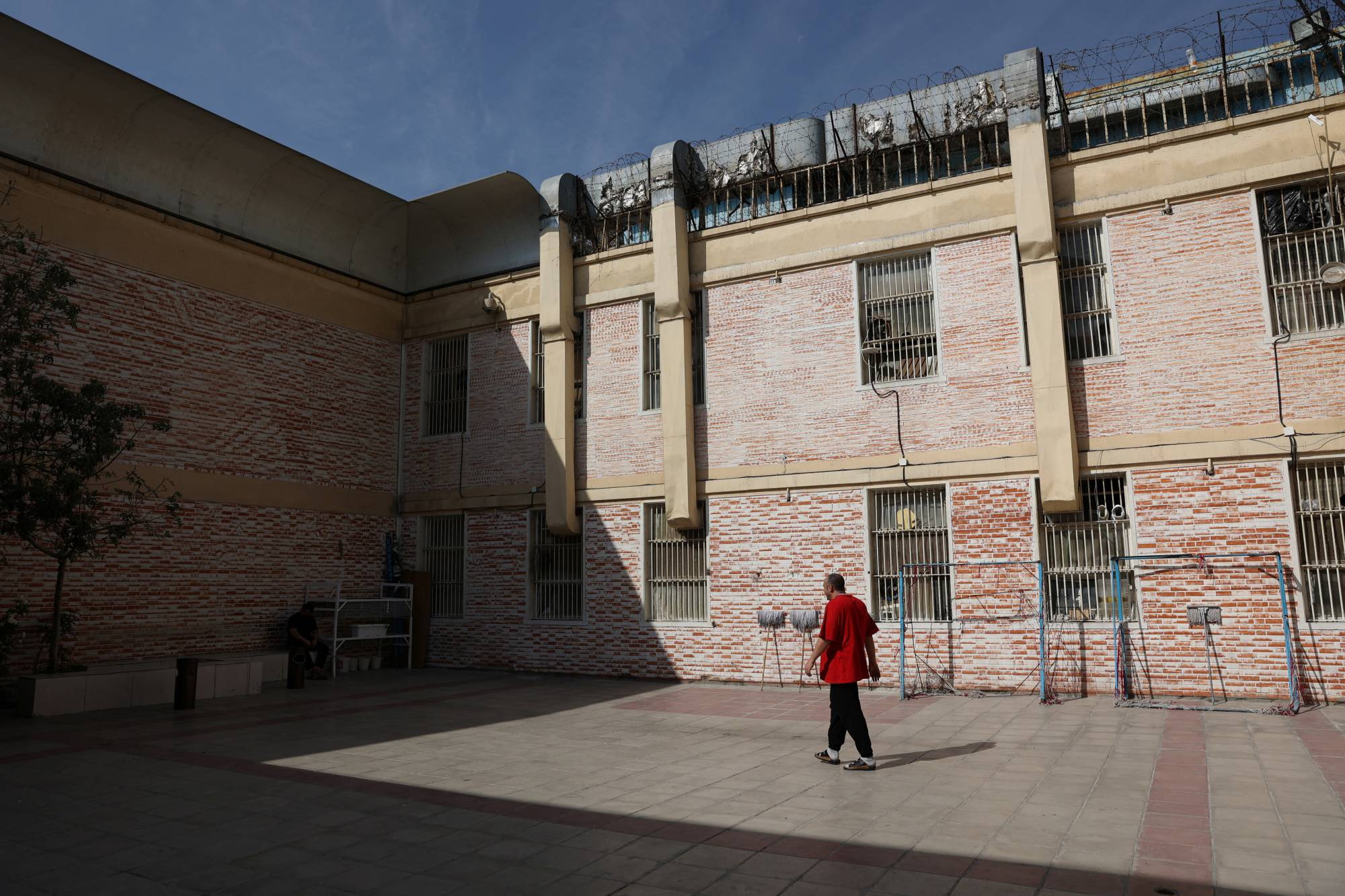 A prisoner walks in the Evin prison yard in Tehran on Monday