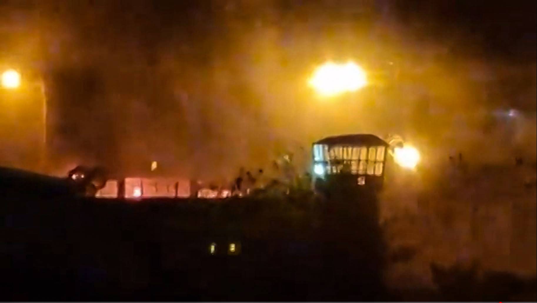 Flames and thick smoke rising from the Evin prison in Tehran on Saturday. Cities across Iran have seen protests since 22-year-old Iranian woman Mahsa Amini died on Sept. 16, after her arrest by the morality police. | UGC / via AFP-JIJI