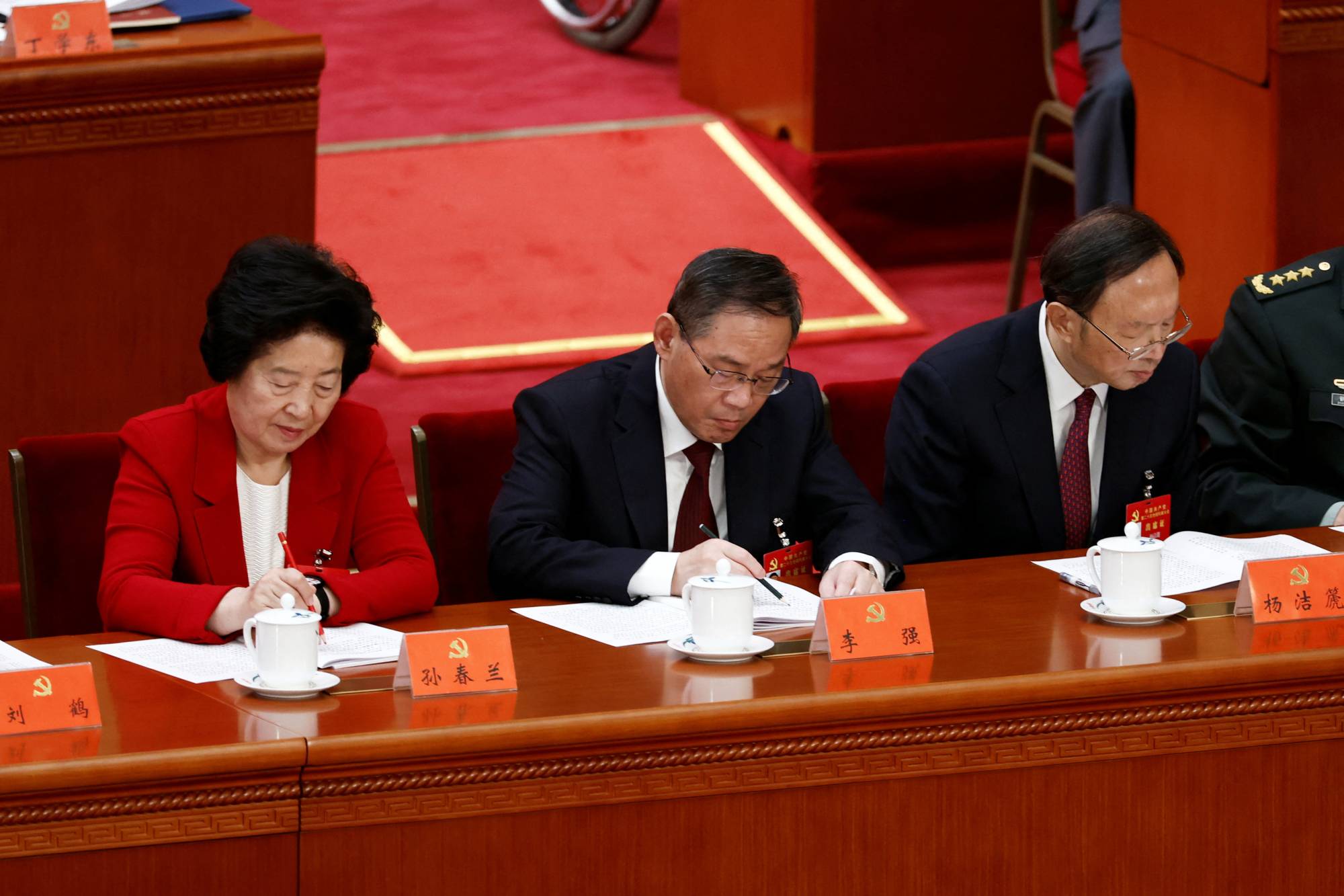 Chinese Vice Premier Sun Chunlan (left), Shanghai Communist Party Secretary Li Qiang (center) and Yang Jiechi, director of the Office of the Central Commission for Foreign Affairs, attend the opening ceremony of the 20th National Congress of the Communist Party of China, at the Great Hall of the People in Beijing on Sunday. | REUTERS