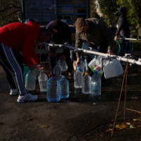 Residents fill up bottles with fresh drinking water, as the main supply pipeline for drinking water for the city was damaged at the beginning of Russia\'s invasion of Ukraine, in Mykolaiv on Thursday.  | REUTERS