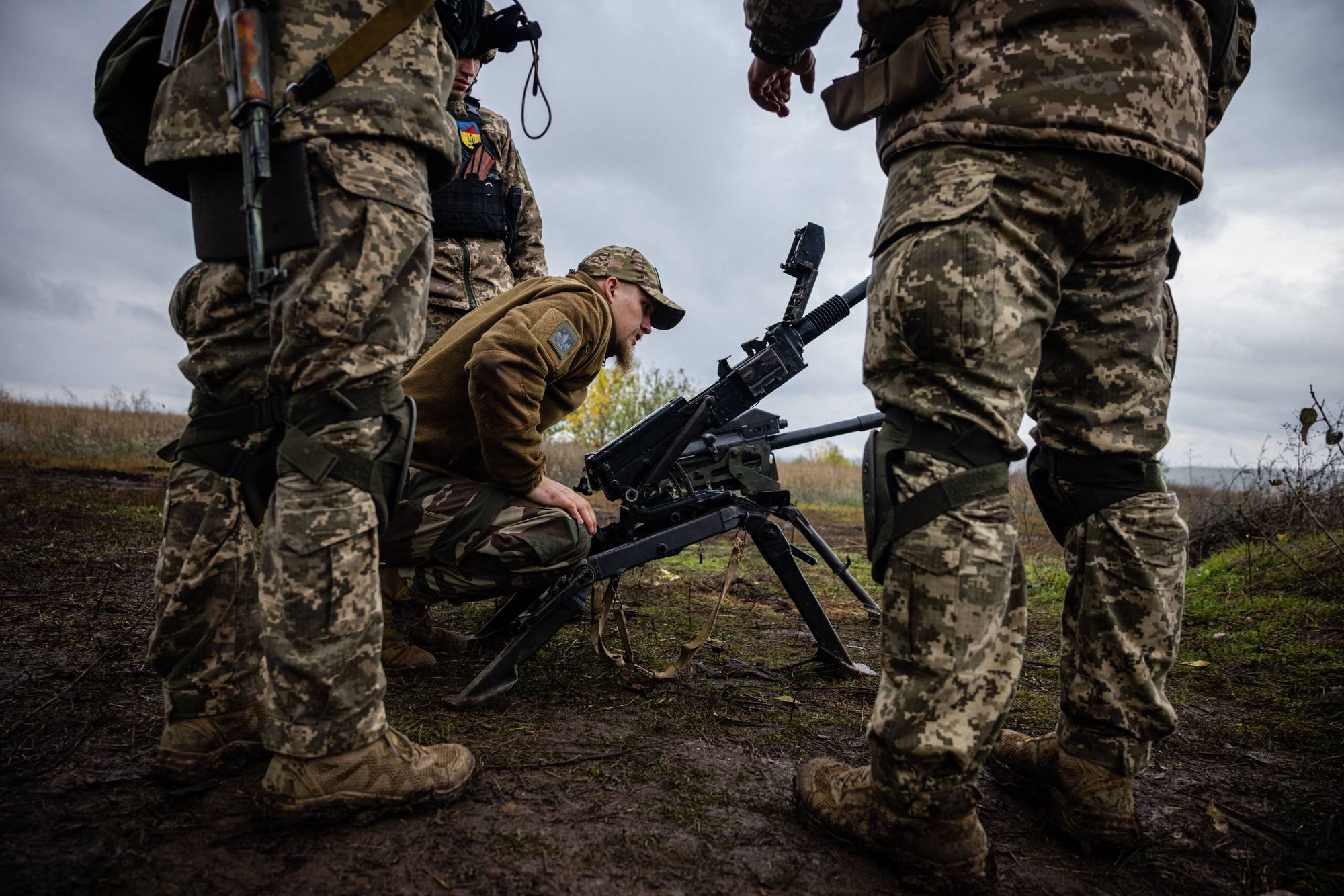 Ukrainian servicemen check their weapons at a position on the front line in eastern Ukraine's Donetsk region on Monday | AFP-Jiji
