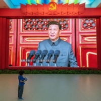 A child stands in front of a video of Xi at the military museum in Beijing on Sept. 2. | GILLES SABRIE / THE NEW YORK TIMES
