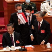 China\'s former president, Hu Jintao, is escorted out of the closing session of the 20th National Congress of the Chinese Communist Party on Saturday. | BLOOMBERG