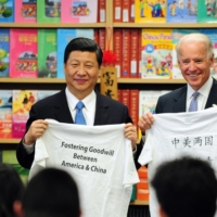 Then-U.S. Vice President Joe Biden and his Chinese counterpart, Xi Jinping, display shirts with a message given to them by students at the International Studies Learning School in Southgate, outside Los Angeles, in  February 2012. | AFP-JIJI