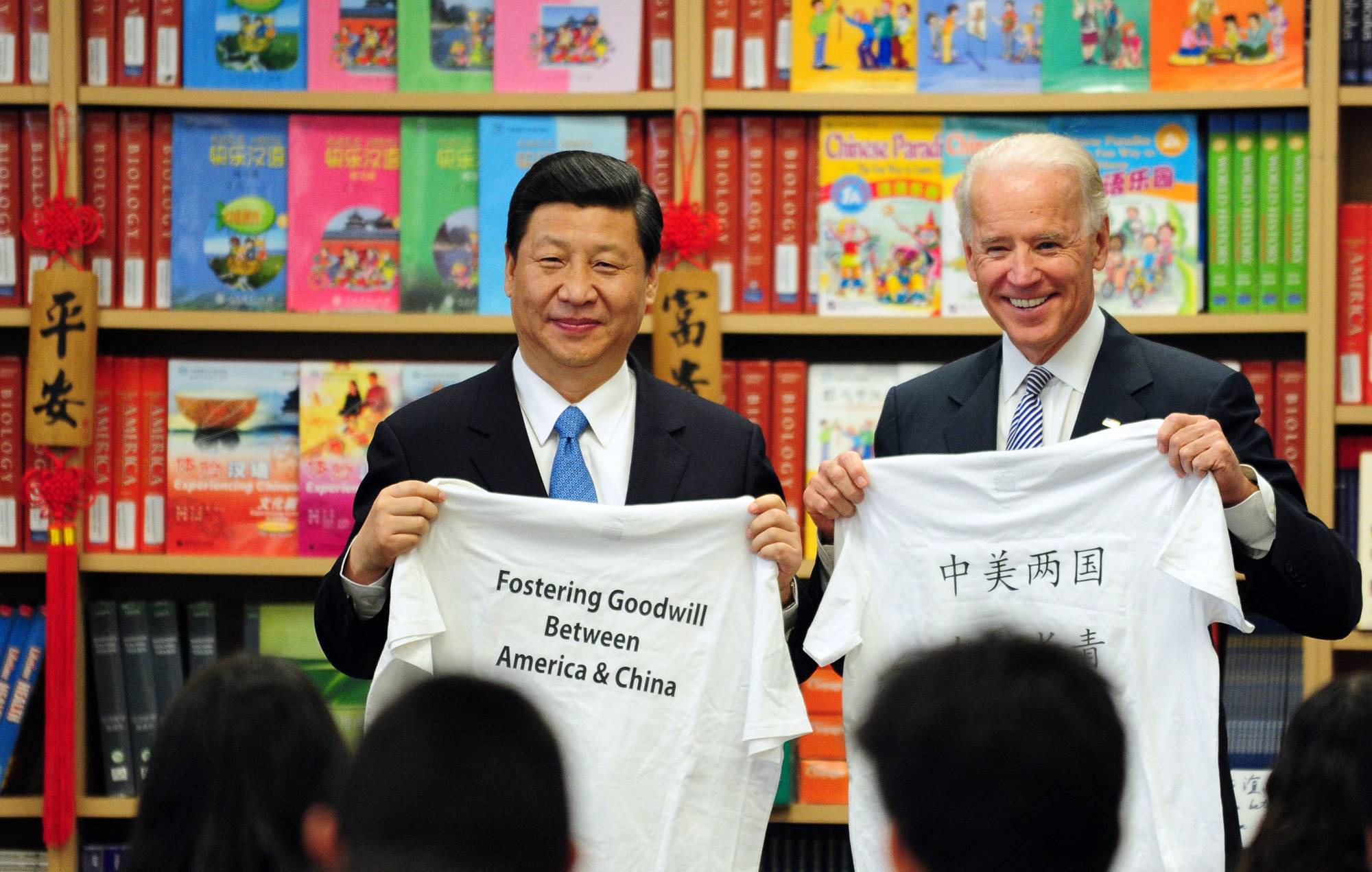 Then-U.S. Vice President Joe Biden and his Chinese counterpart, Xi Jinping, display shirts with a message given to them by students at the International Studies Learning School in Southgate, outside Los Angeles, in February 2012. | AFP-JIJI