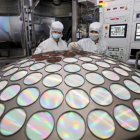Employees work on the semiconductor chip production line of Jiangsu Azure Corp. in Huaian, in China\'s Jiangsu province, in March. | CHINA DAILY / VIA REUTERS