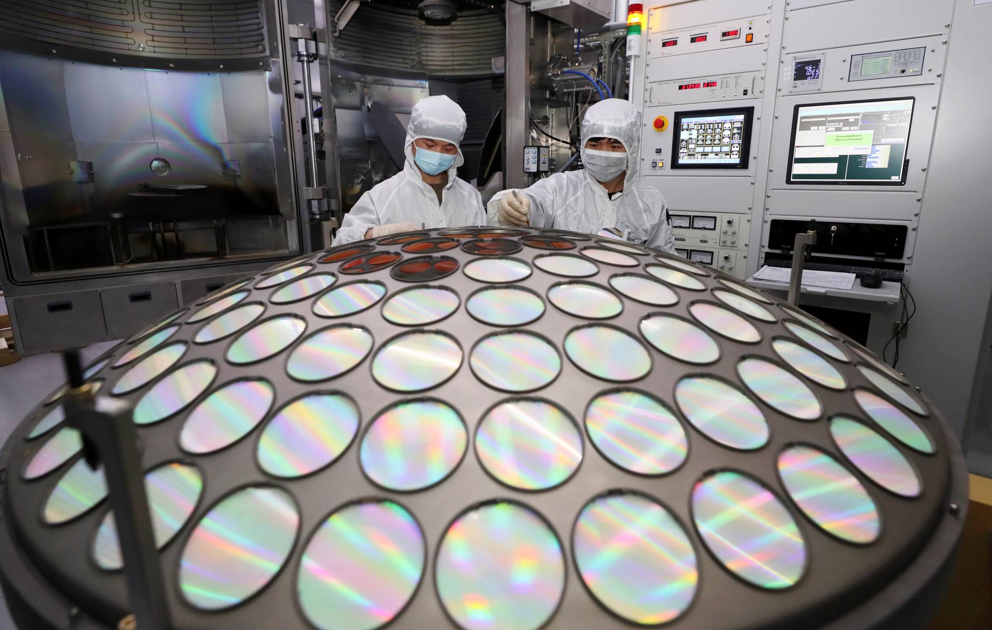 Employees work on the semiconductor chip production line of Jiangsu Azure Corp. in Huaian, in China's Jiangsu province, in March. | China Daily / via REUTERS