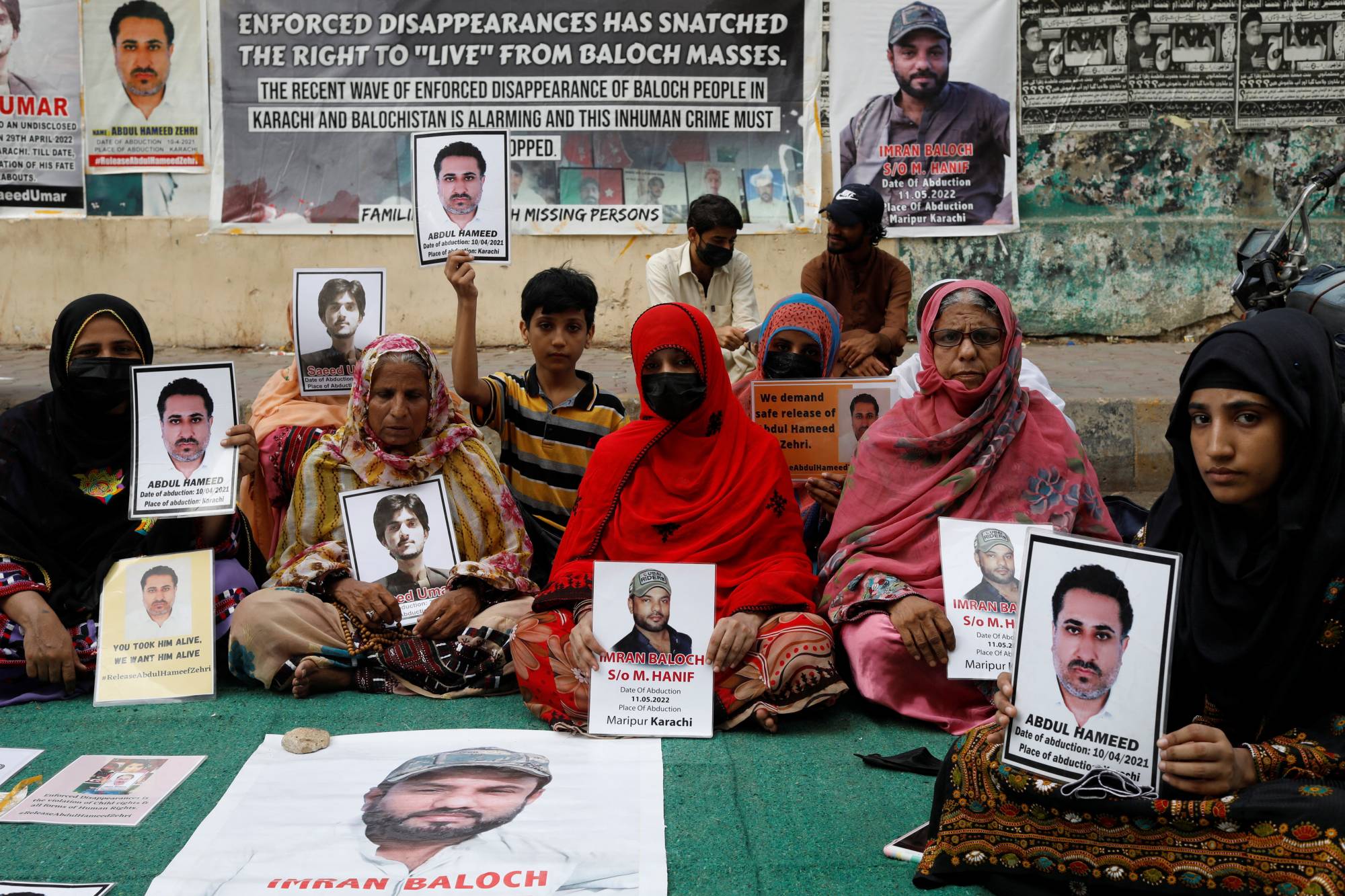Family members of missing or disappeared persons hold portraits of their loved ones during a protest in Karachi in July. | REUTERS