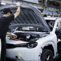 Workers assemble a Mazda Motor MX-30 EV on the production line at the company\'s Ujina plant in Fuchu, Hiroshima Prefecture, in June. | BLOOMBERG