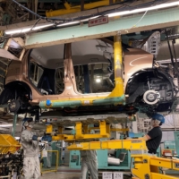 Workers install a battery in an electric vehicle at Mitsubishi Motor\'s factory in Kurashiki, Okayama Prefecture, in May. | REUTERS