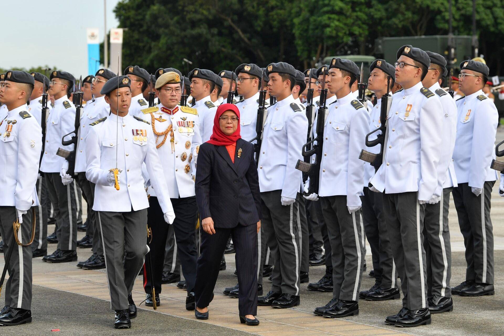 Singapore Lt. Gen. Melvyn Ong walks with President Halimah Yacob during an Inauguration Parade at the SATI Military Institute in the city-state on Friday. | SINGAPORE DEFENSE MINISTRY