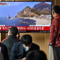 A television screen at a station in Seoul shows a news broadcast with live footage of the island of Ulleungdo on Wednesday. | AFP-JIJI
