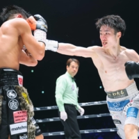 Kenshiro Teraji (right) attacks Hiroto Kyoguchi during the third round of their light flyweight unification bout in Saitama on Tuesday. | POOL / VIA KYODO