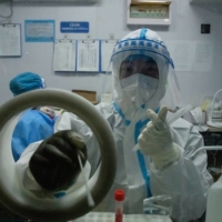 A worker at a temporary COVID-19 testing site in Beijing on Sept. 24. | GILLES SABRI / THE NEW YORK TIMES