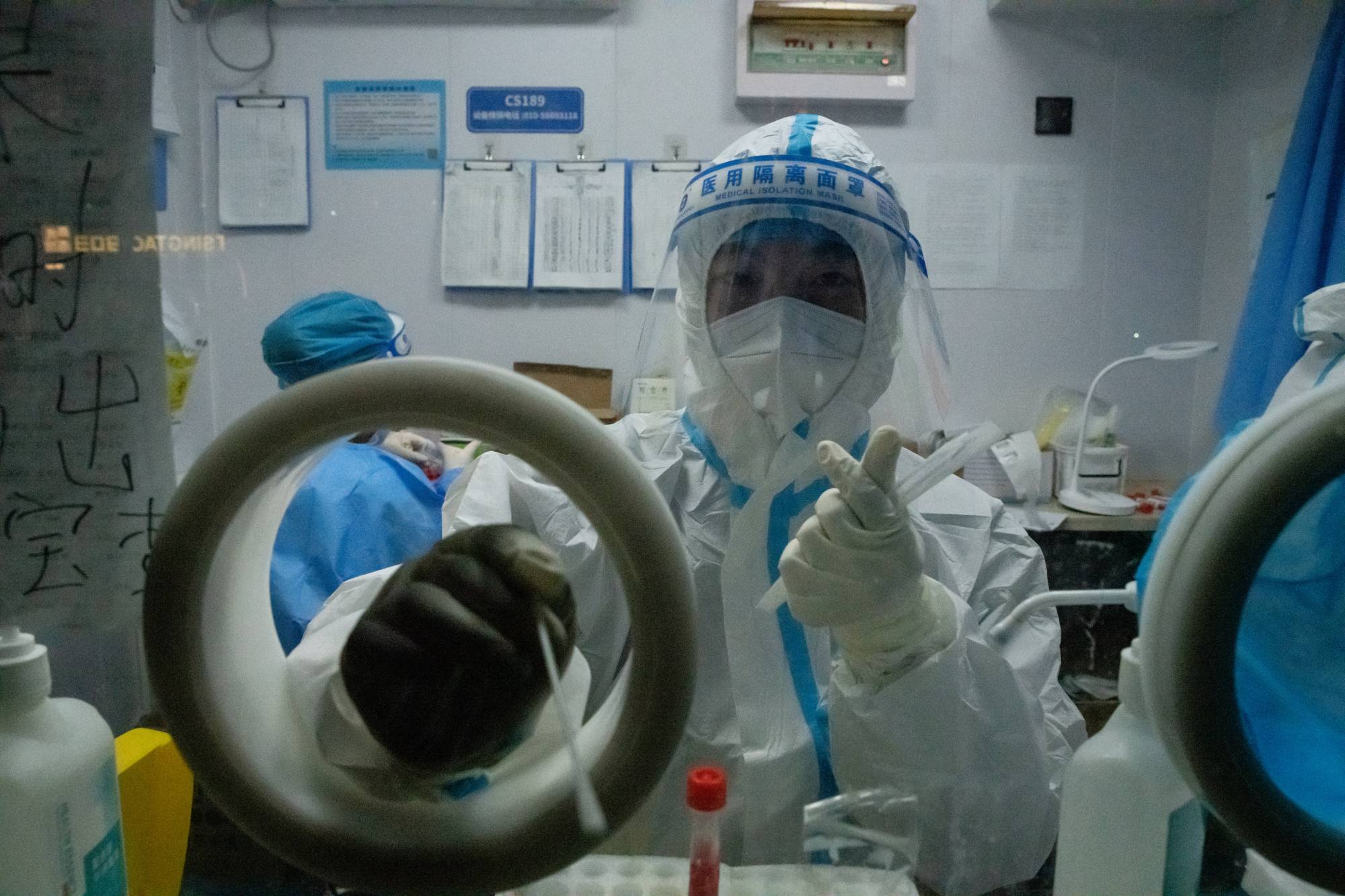 A worker at a temporary COVID-19 testing site in Beijing on Sept. 24. | Gilles Sabri / The New York Times