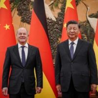 Chinese President Xi Jinping (right) welcomes German Chancelor Olaf Scholz at the Grand Hall in Beijing on Friday. | POOL / VIA AFP-JIJI