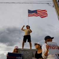 Supporters of Sen. Marco Rubio, a Republican from Florida, hold signs ahead of an election debate in Lake Worth, Florida, on Oct. 18.  | BLOOMBERG 