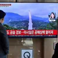 A news broadcast with file footage of a North Korean missile launch at a railway station in Seoul on Wednesday. | AFP-JIJI