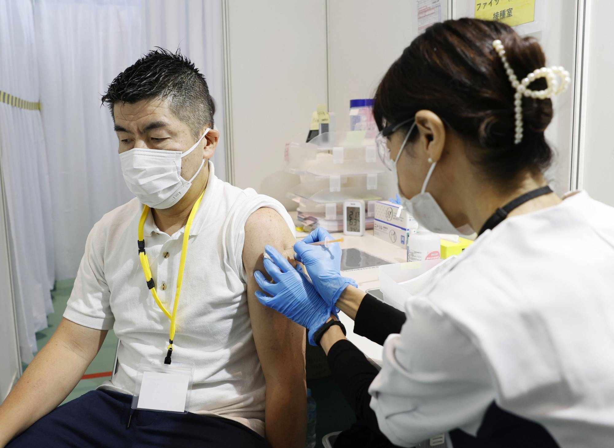 A man receives a COVID-19 booster shot at the Tokyo Metropolitan Government building in October. | KYODO