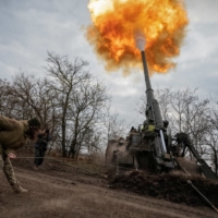 A Ukrainian servicewoman fires a 2S7 Pion self-propelled gun at a position on the front line in Kherson, Ukraine on Wednesday. | REUTERS