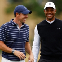 Tiger Woods (right) speaks with Rory McIlroy during a four-hole event in St. Andrews, Scotland, on July 11. | REUTERS