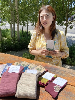 Maari Wada, owner of Live Your Color, a hosiery textile business based in Portland, Oregon, explains her sock lineup in June. | KYODO