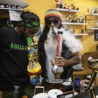 Smokers use a bong at the Rolloft dispensary in Bangkok. Cannabis shops have multiplied in Thailand since the drug was decriminalized, with caveats, in June. Some lawmakers are now pushing for tighter regulation.  | LAUREN DECICCA / THE NEW YORK TIMES