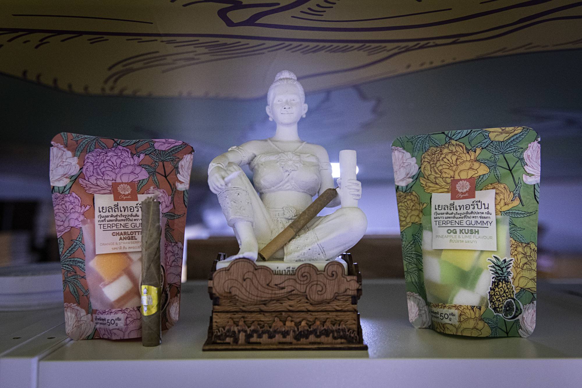 A joint rests on a Buddhist figurine at Chopaka, a marijuana dispensary in Bangkok  | Lauren DeCicca / The New York Times