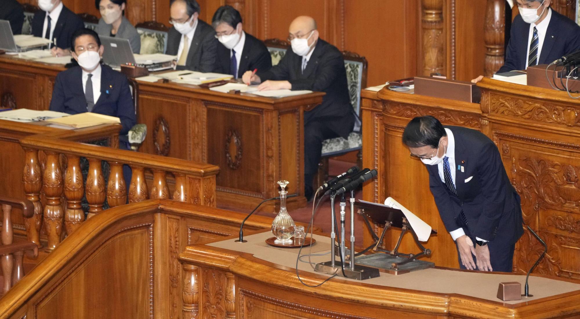 Justice Minister Yasuhiro Hanashi (right) bows in apology during a the Upper House plenary session Friday as Prime Minister Fumio Kishida looks on. | KYODO