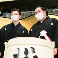 Terunofuji (right) will miss the upcoming Kyushu Basho due to a knee injury. | KYODO