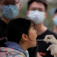A woman gets tested for the coronavirus at a nucleic acid testing site, following an outbreak in Shanghai, on Friday. | REUTERS