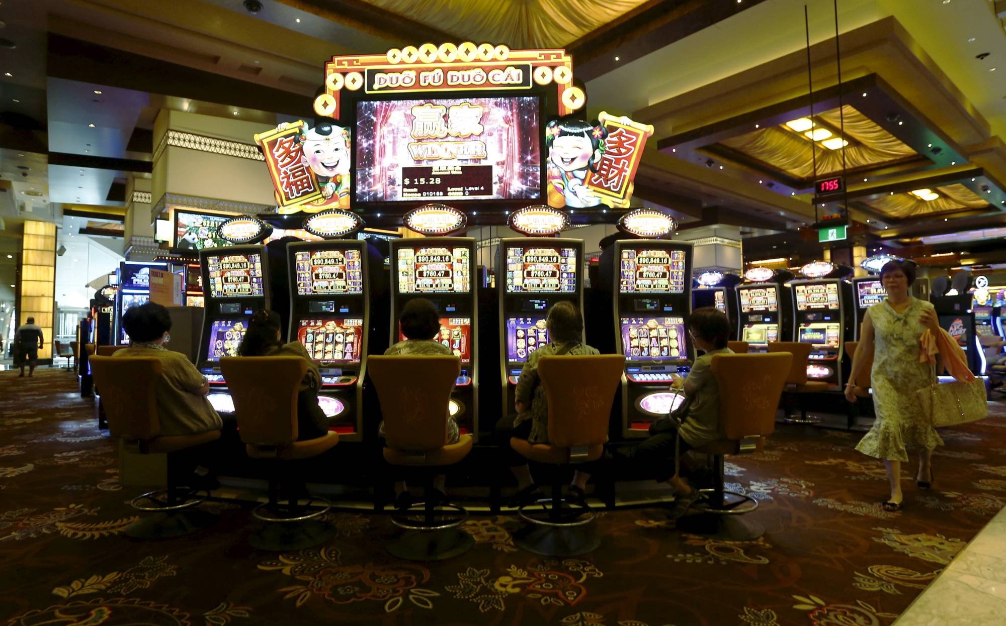 Visitors to Sydney's Star Casino play electronic slot machines in 2016. Problem gambling affects about 1% of Australians. | REUTERS
