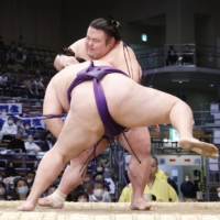 Ozeki Takakeisho (behind) is forced out by maegashira Meisei during Day 4 of the Kyushu Grand Sumo Tournament in Fukuoka on Wednesday. | KYODO