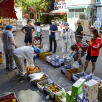Residents shop at a fruit stall amid a COVID-19 outbreak in the Tianshan district of Urumqi, in China\'s Xinjiang Uyghur Autonomous Region, on Sept. 5.  | CNSPHOTO VIA / REUTERS  